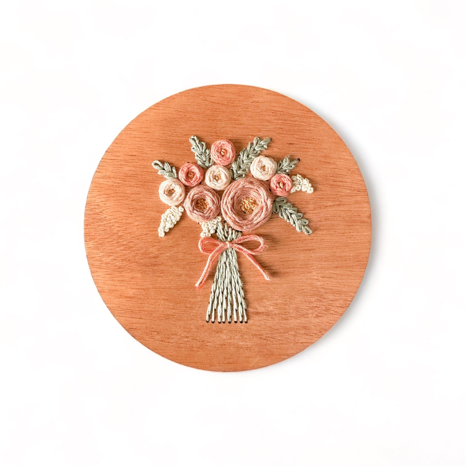 A sample of arose bouquet embroidery kit created with blush colored threads.