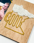 Close up of a ample of a picture frame for a Minnesota beer embroidery kit design.