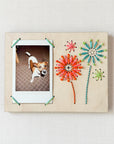 Embroidered instant photo frame with firework decoration.